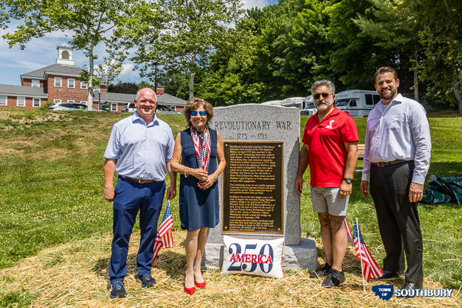 group of people around a monument with southbury town hall in the background