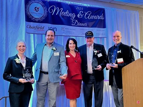 group on stage with awards