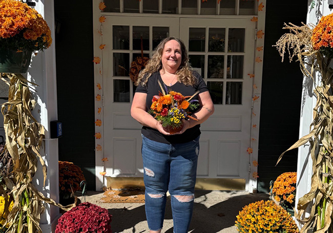 kim bova holding the flower arrangement