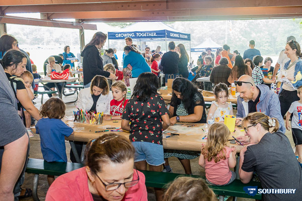 outdoor pavilion filled with people doing crafts and painting