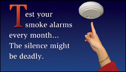Finger pressing smoke alarm test button