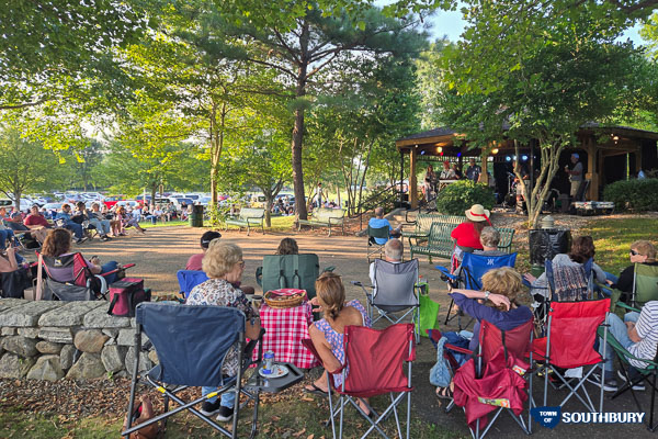 people in lawn chairs listening to a concert